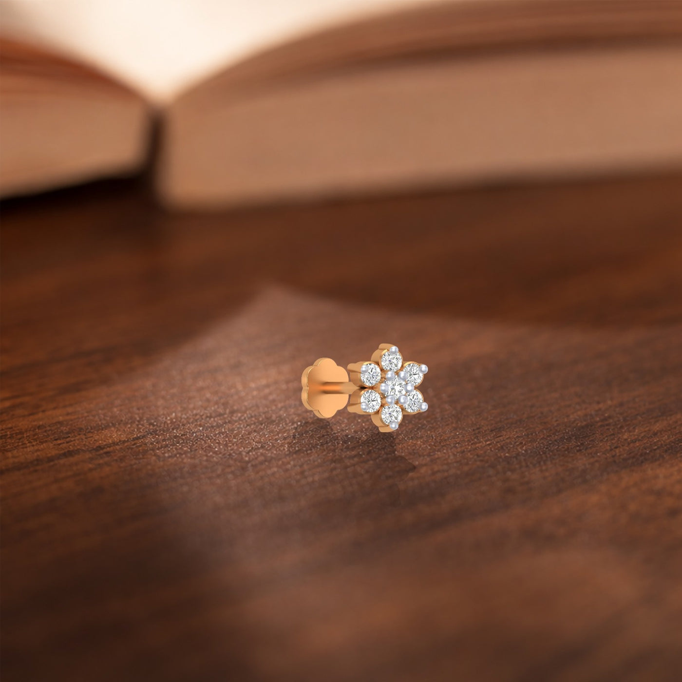 Yellow Gold and diamond stud nose pin on a wooden surface
