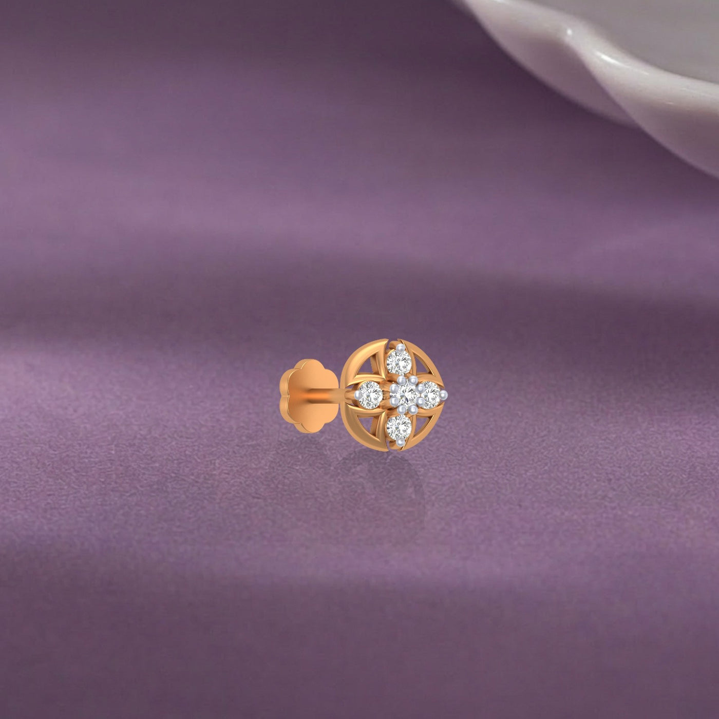 yellow gold and diamond stud nose pin on a purple fabric background