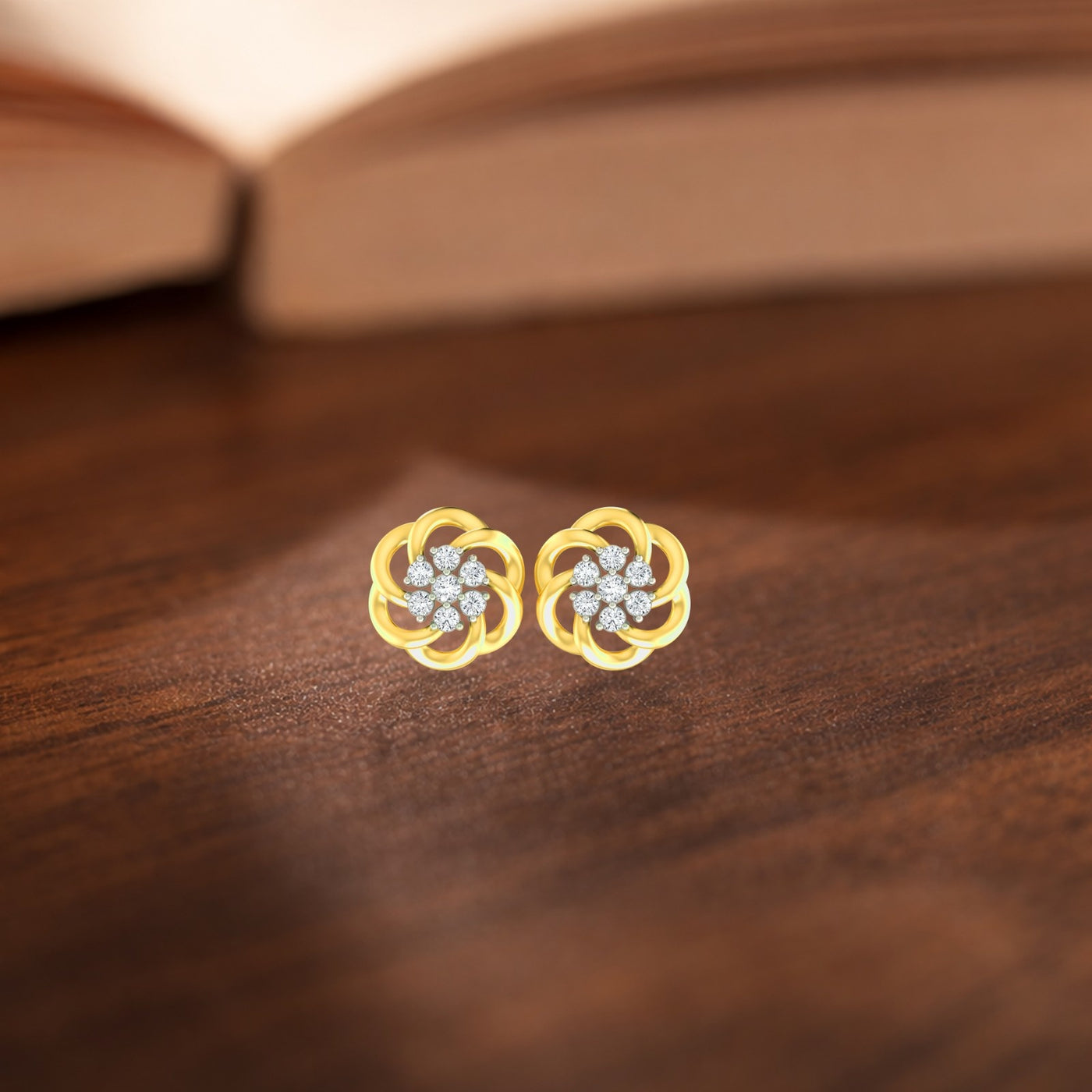 Gold and diamond stud earring with flower-shaped on a wooden surface.