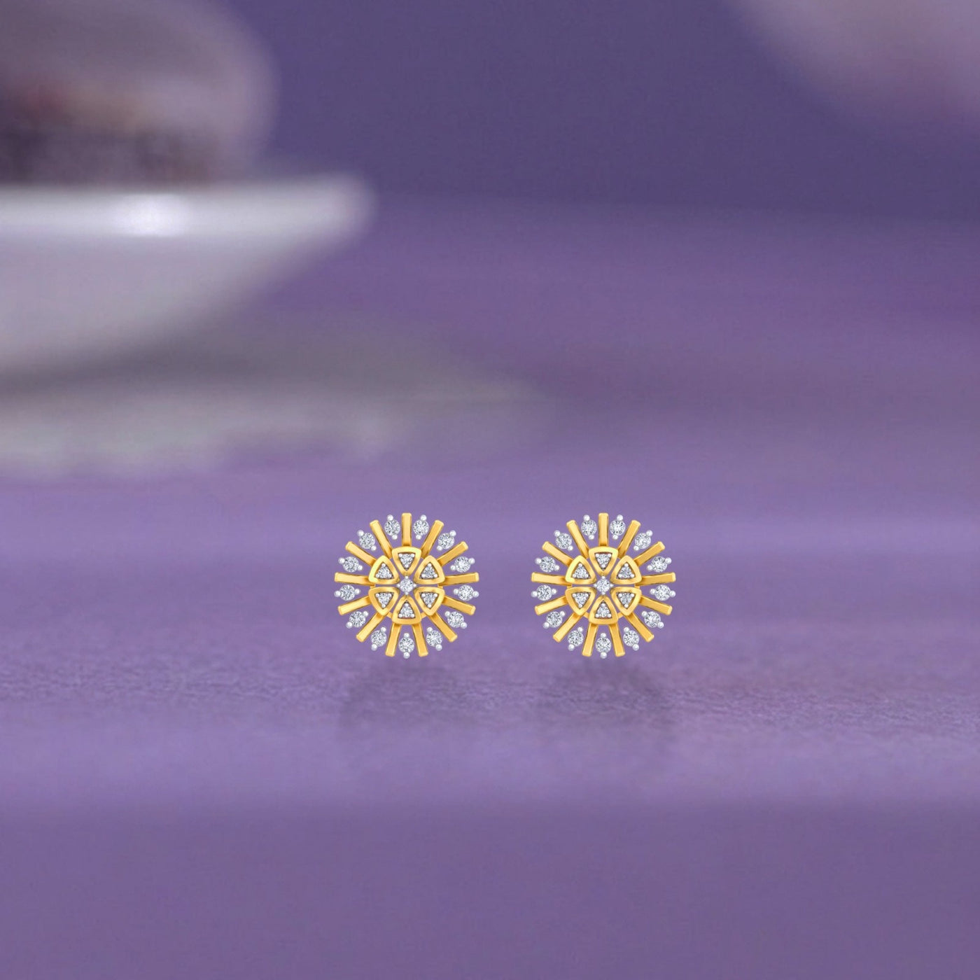 Gold & diamond floral stud earrings for women on a purple background.
