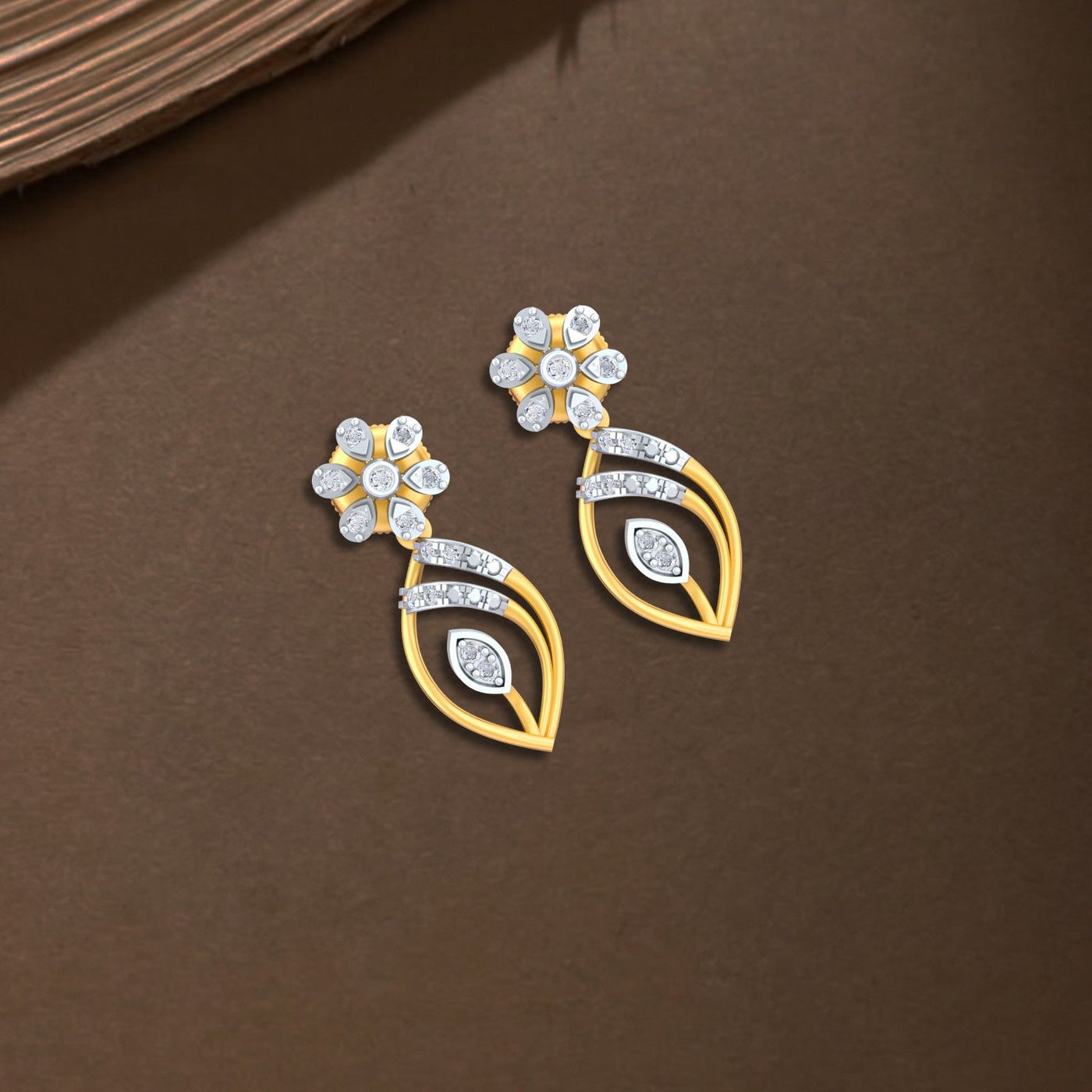 Yellow gold and diamond dangler earring on a brown background.