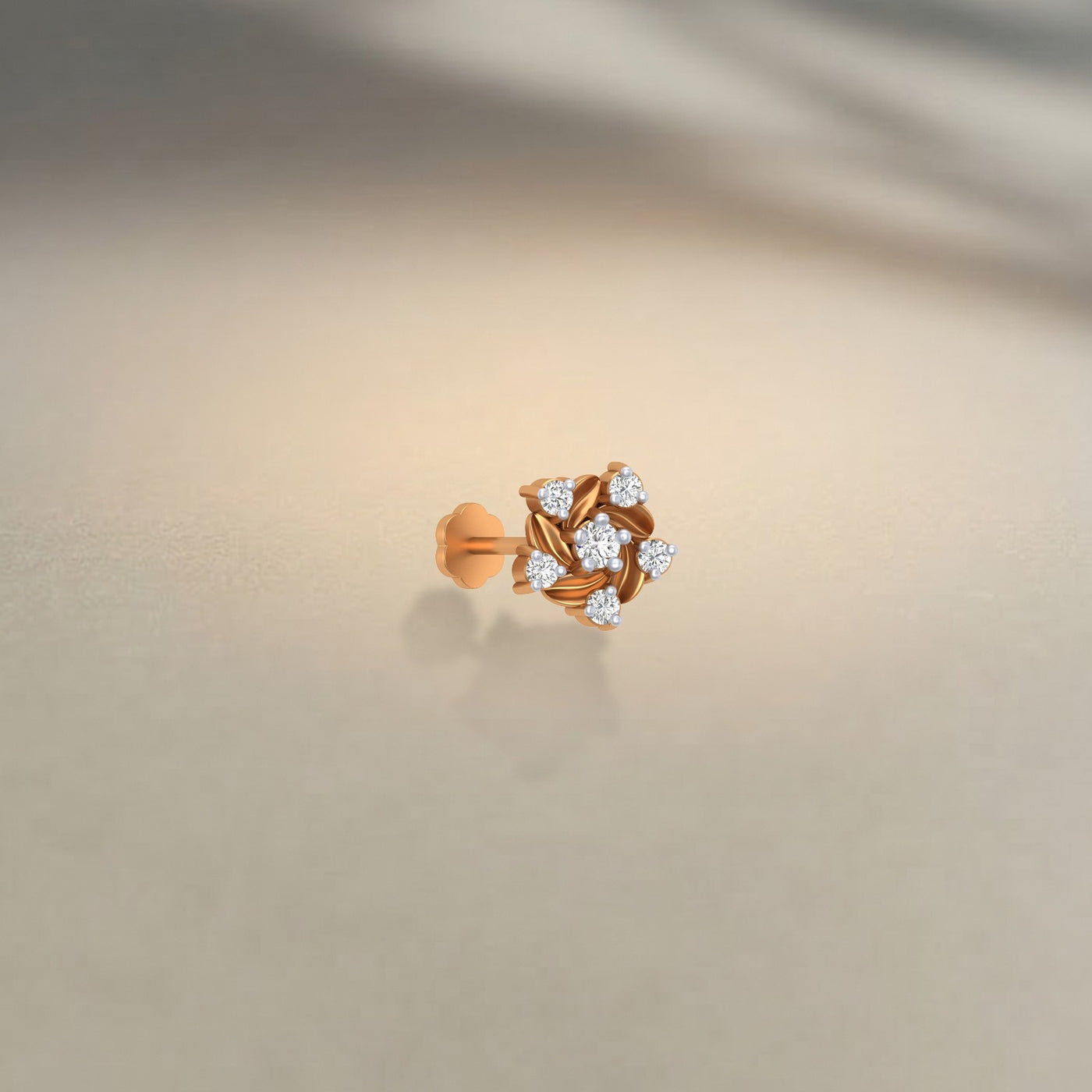 yellow gold and diamond stud nose pin accents on a beige background