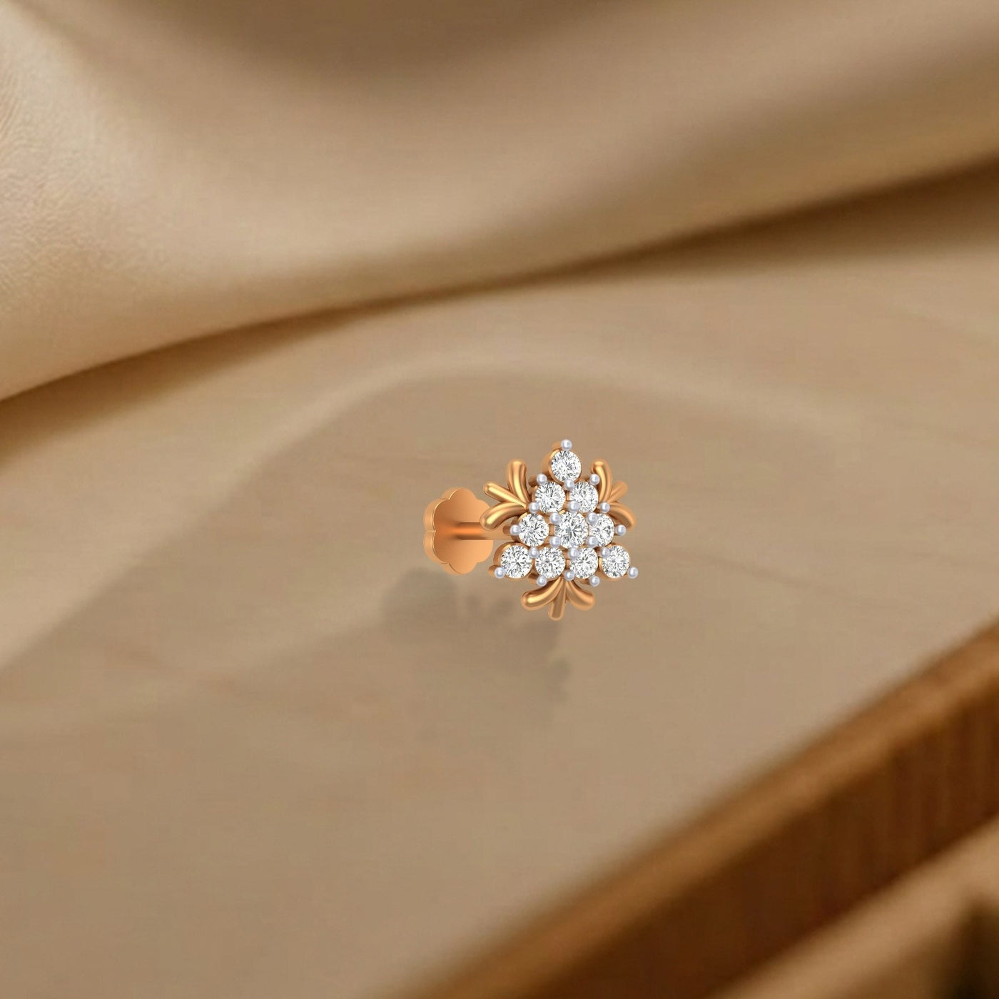 yellow gold and diamond nose pin with diamonds on a beige fabric background