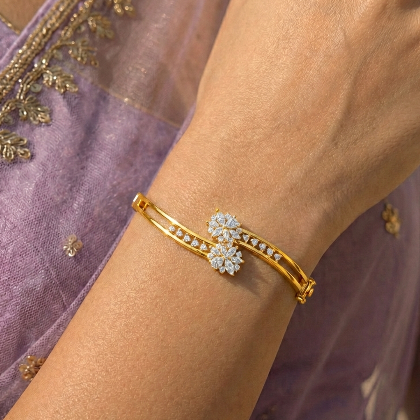 Elegant yellow gold and diamond floral bracelet worn on a woman's wrist, featuring sparkling flower motifs and a modern open bangle design.