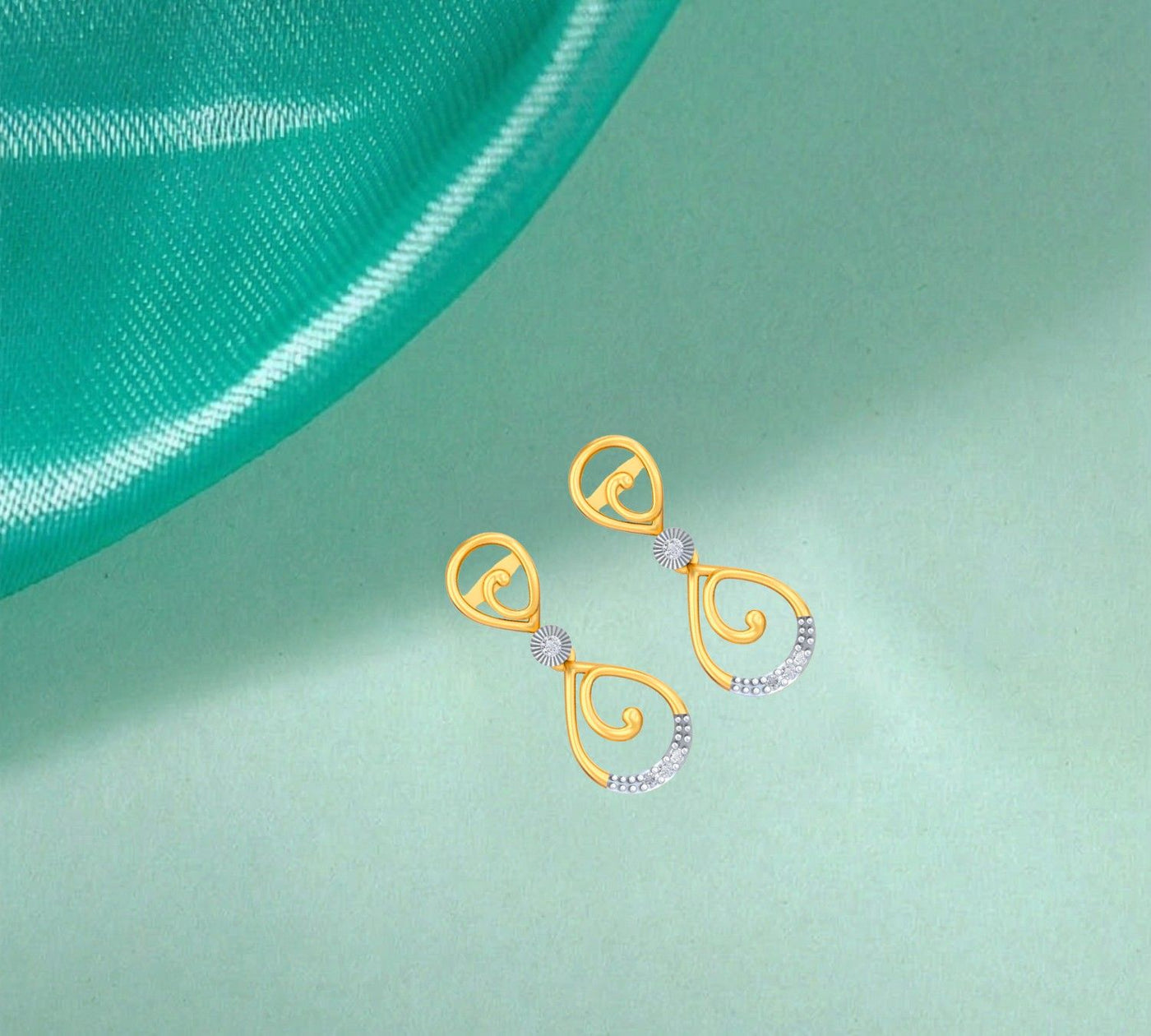 Gold and diamond drop earring on a green background