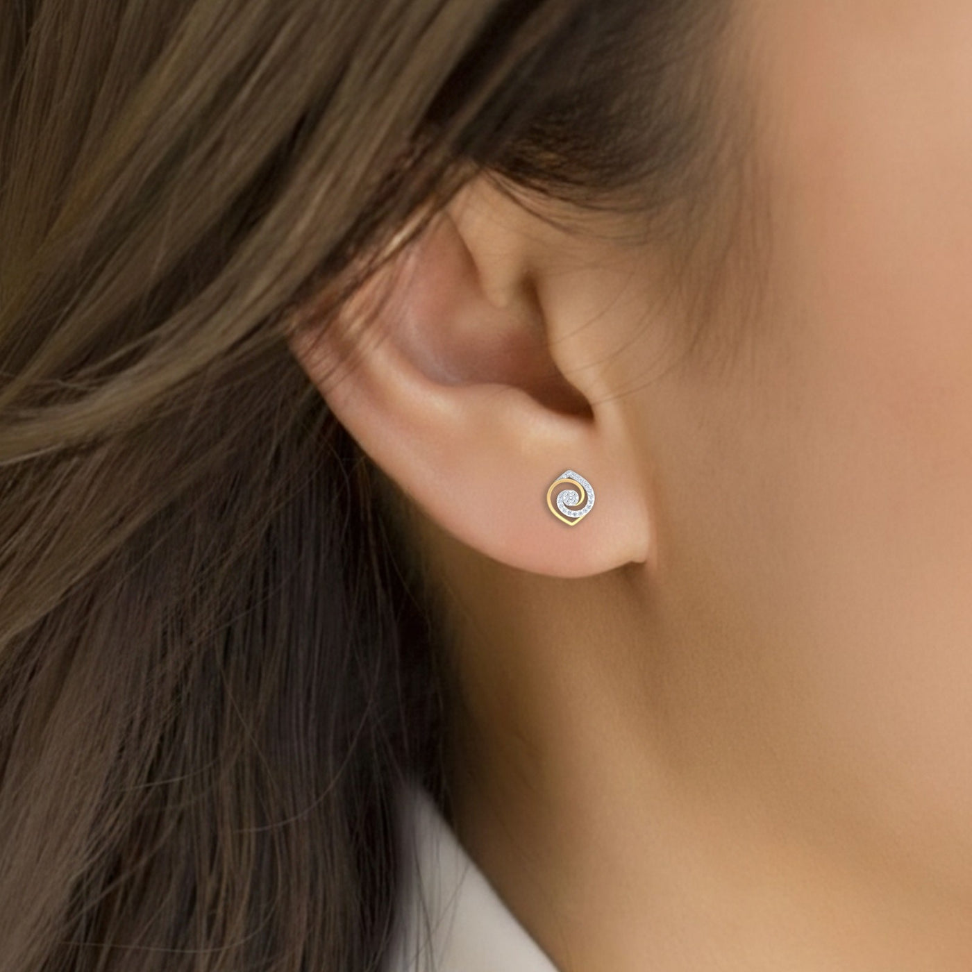 Close-up shot of a gold and diamond spiral earrings.