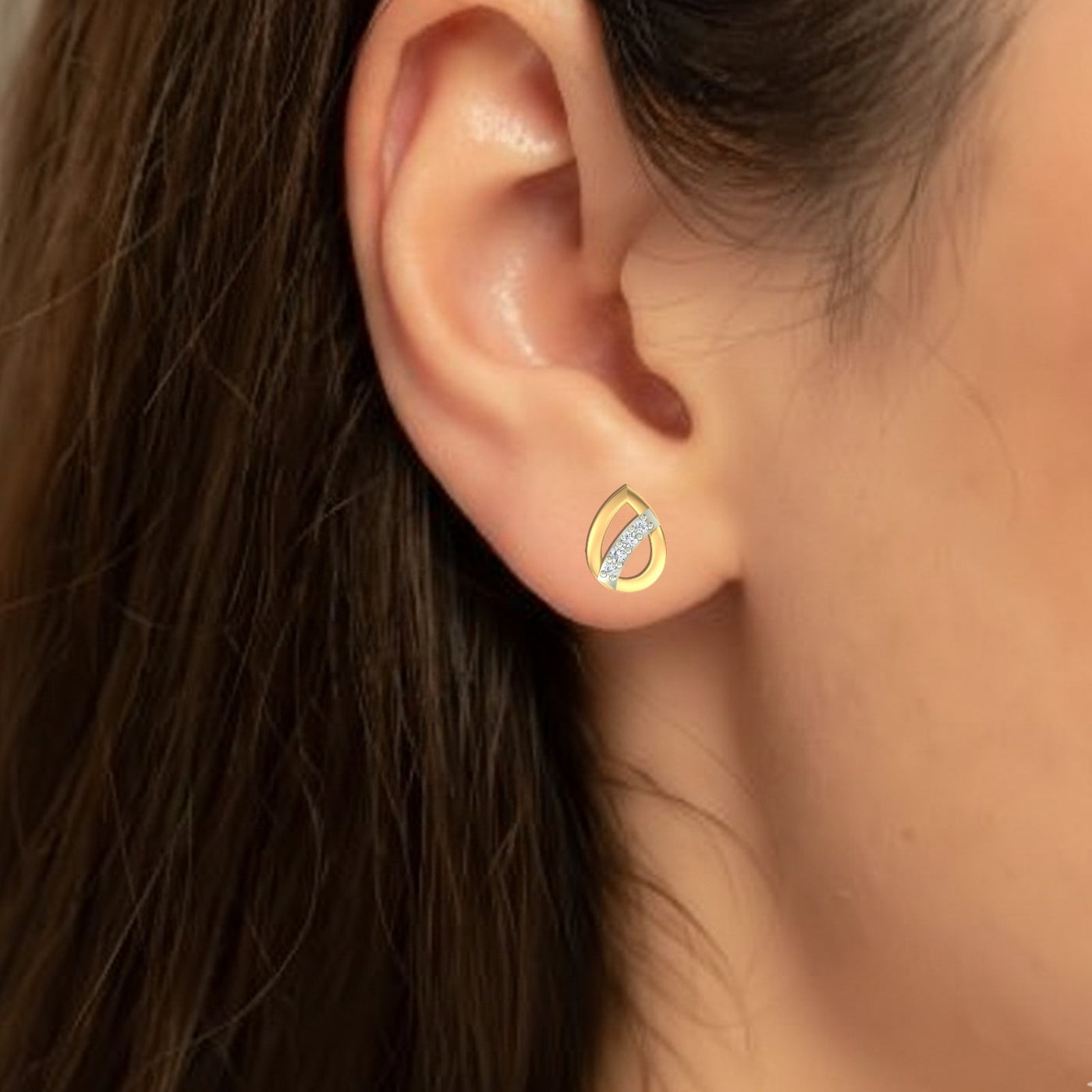 Close-up shot of a gold and diamond pear-shaped stud earrings