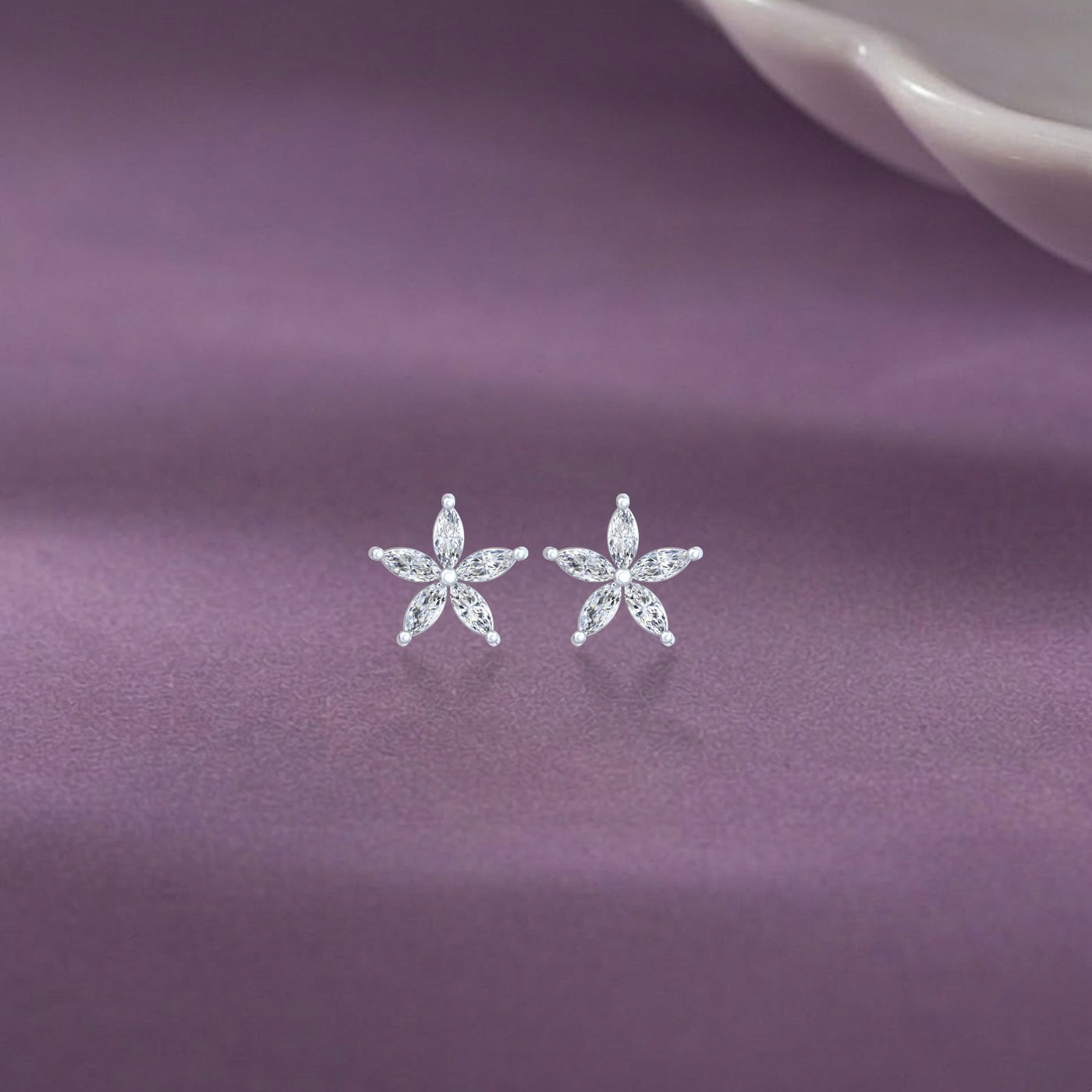 Gold and diamond stud earring with floral-design on a purple background