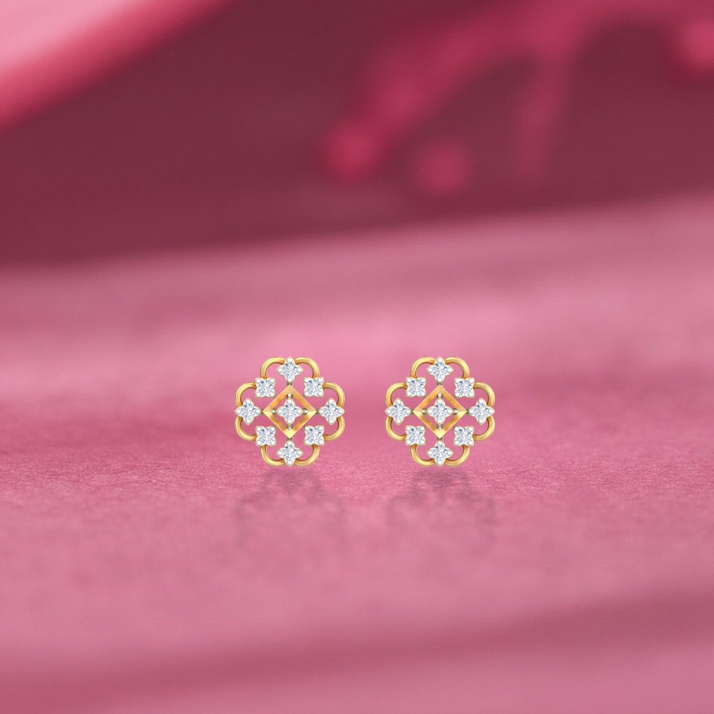 Gold and diamond stud earring with floral-design on a pink background.