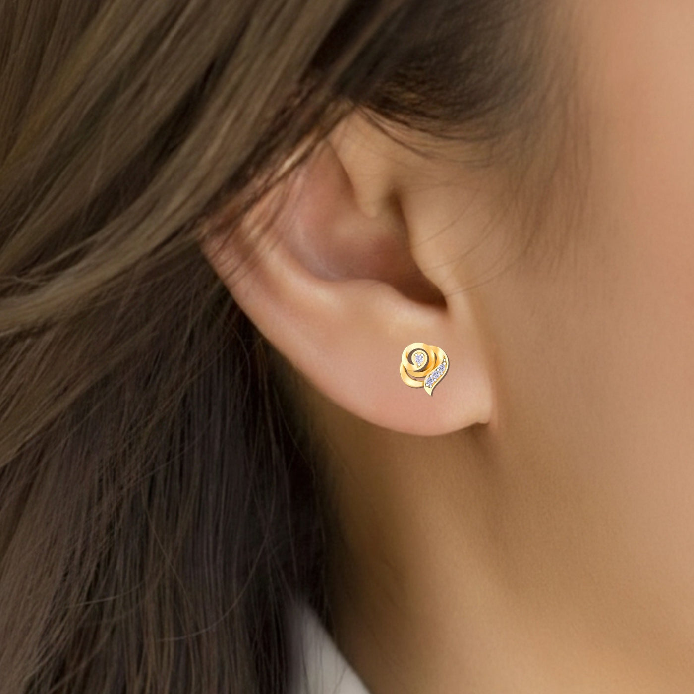 Gold and diamond stud earring on a person's ear 