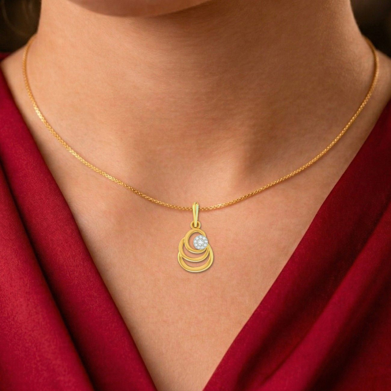 Gold necklace with a pendant on a person wearing a red garment