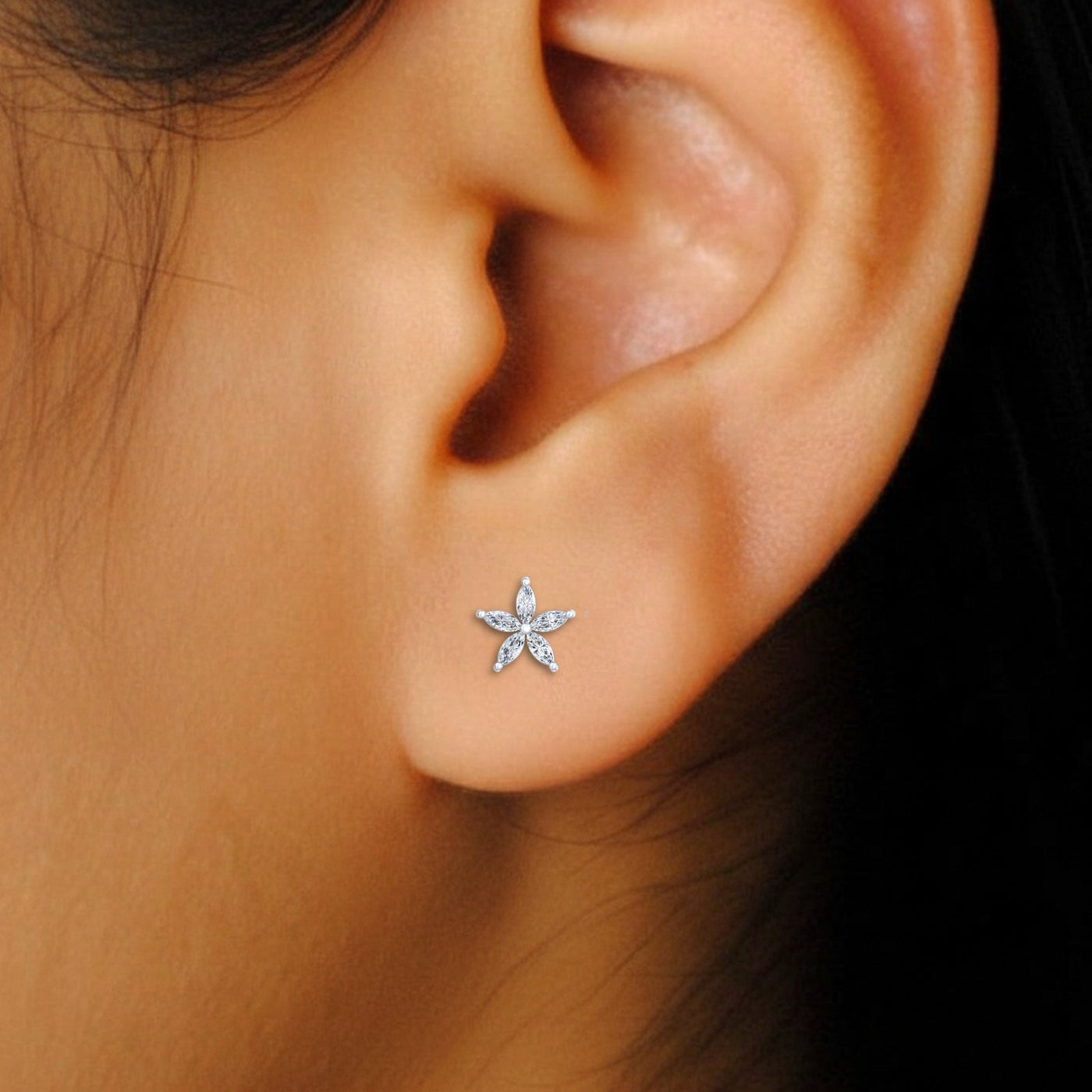 Close-up shot of a gold and diamond floral stud earring.