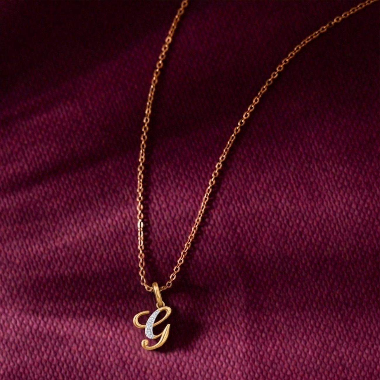 Gold necklace with a letter 'G' pendant on a purple fabric background