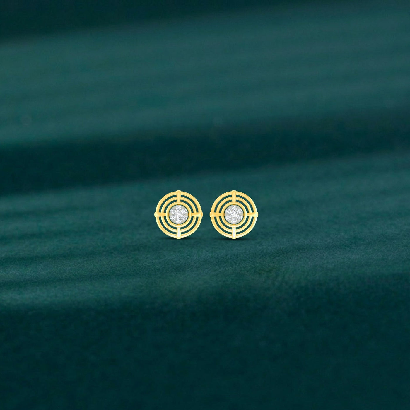 Gold and diamond stud earrings with circular design on a green fabric background
