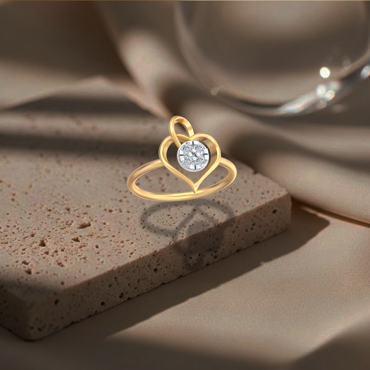 Gold ring with a heart design and diamond on a textured brown surface