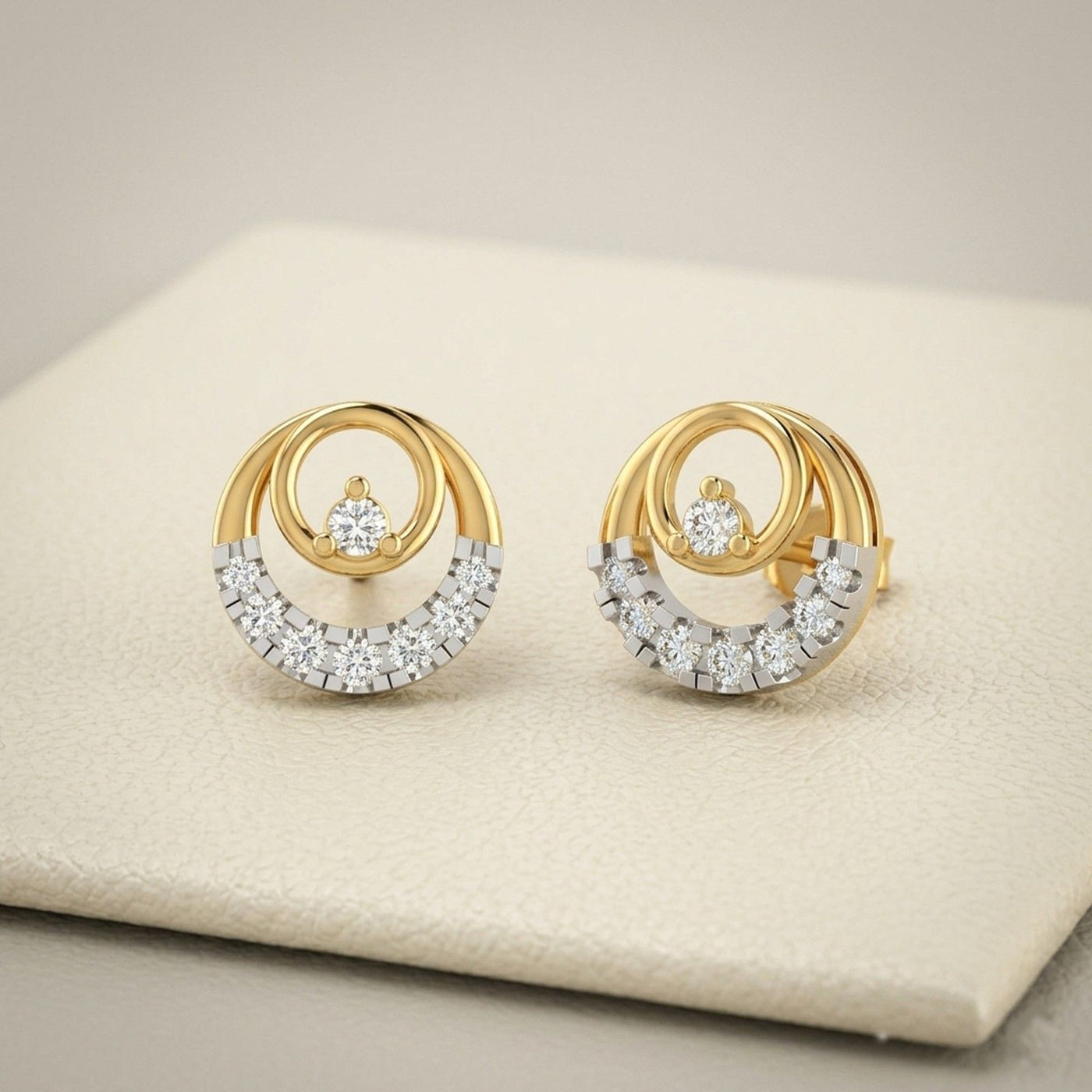 Gold and diamond round-shaped earrings on a beige fabric background