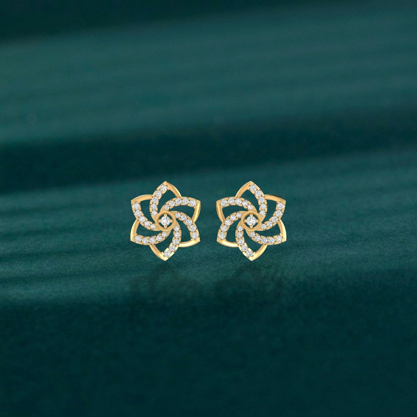 Gold and diamond floral-design stud earrings on a teal background