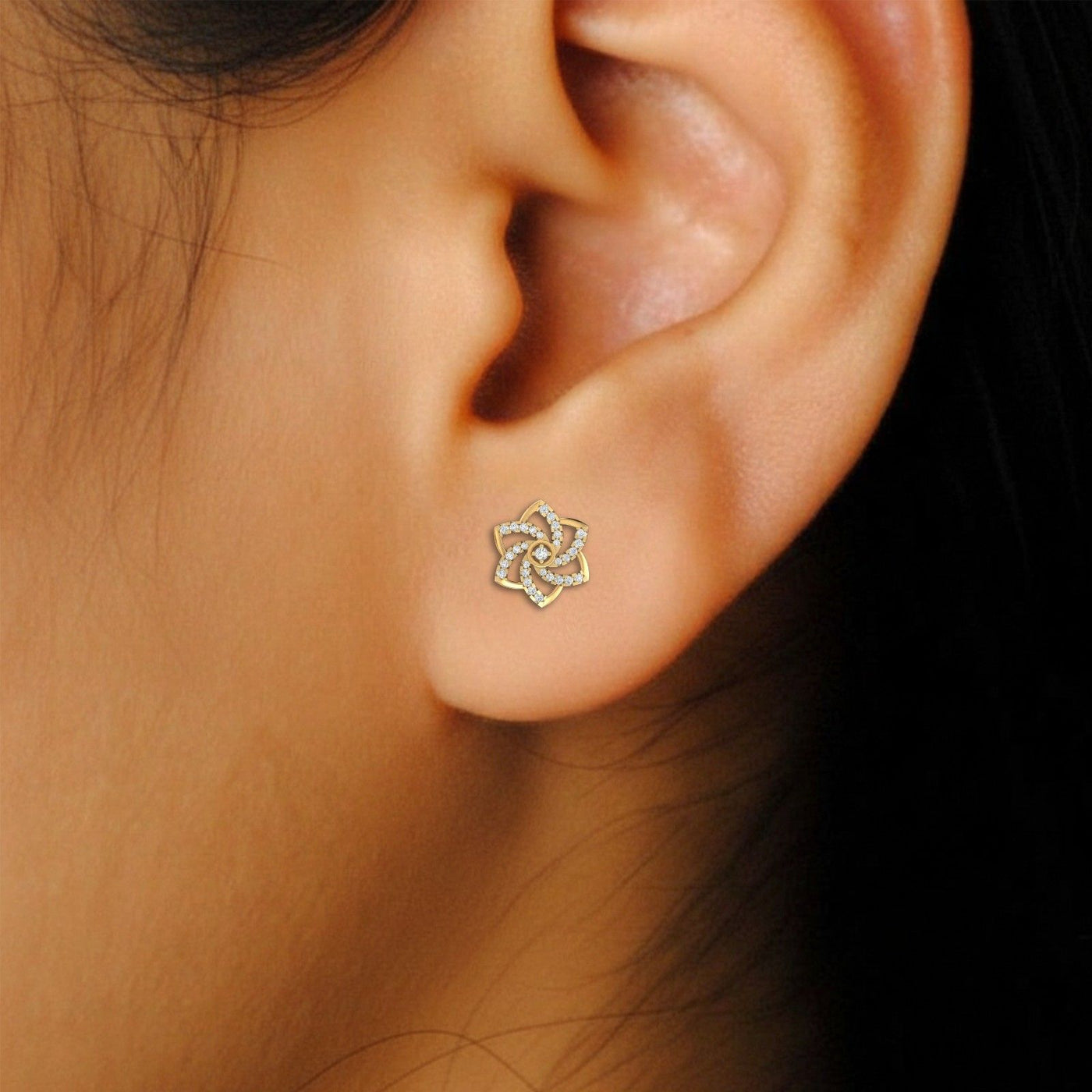 Close-up shot of a gold and diamond floral-design stud earrings.