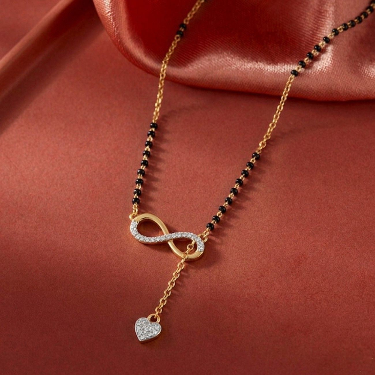 gold & diamond modern infinity mangalsutra on red background