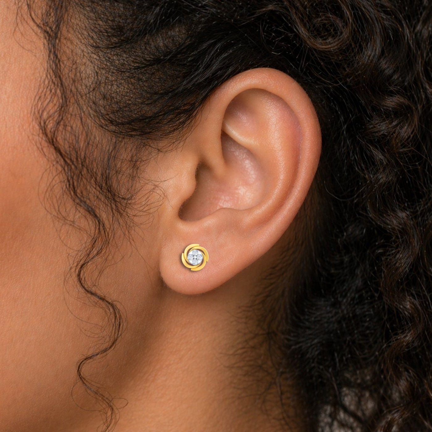 Close-up shot of a gold and diamond round-shaped stud earrings.