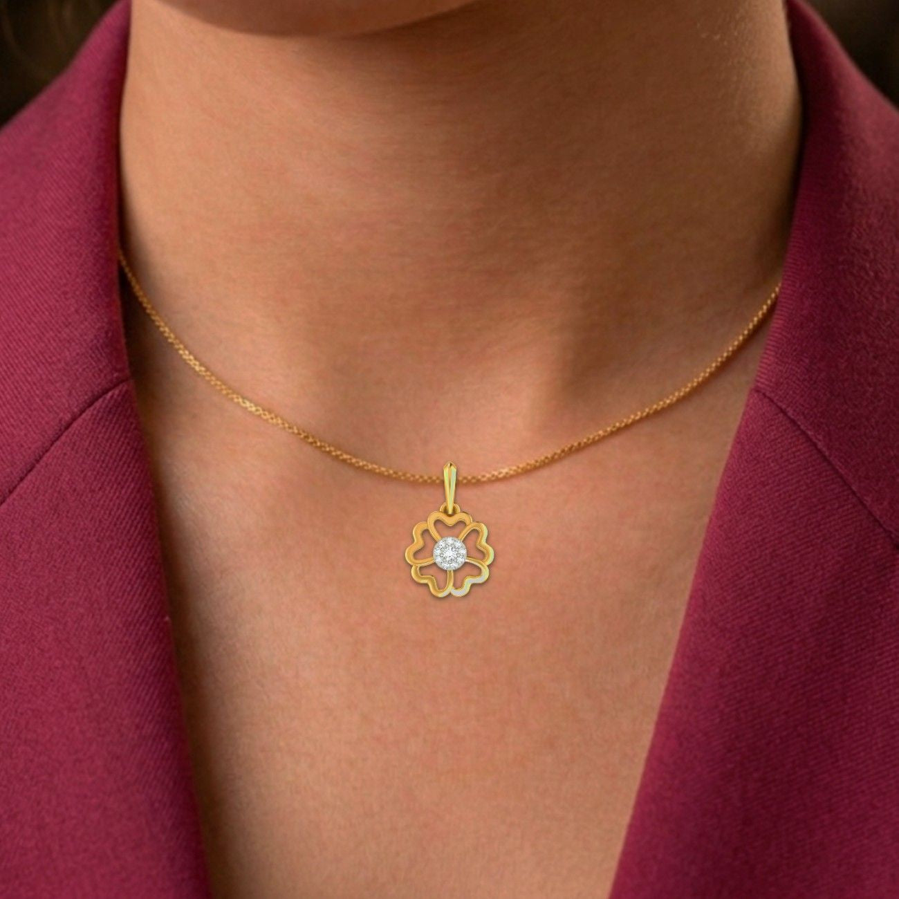 Gold necklace with a floral pendant on a person wearing a red garment.