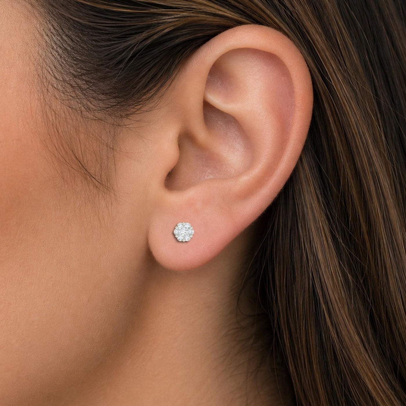 Close-up shot of a gold and diamond floral-design stud earrings.