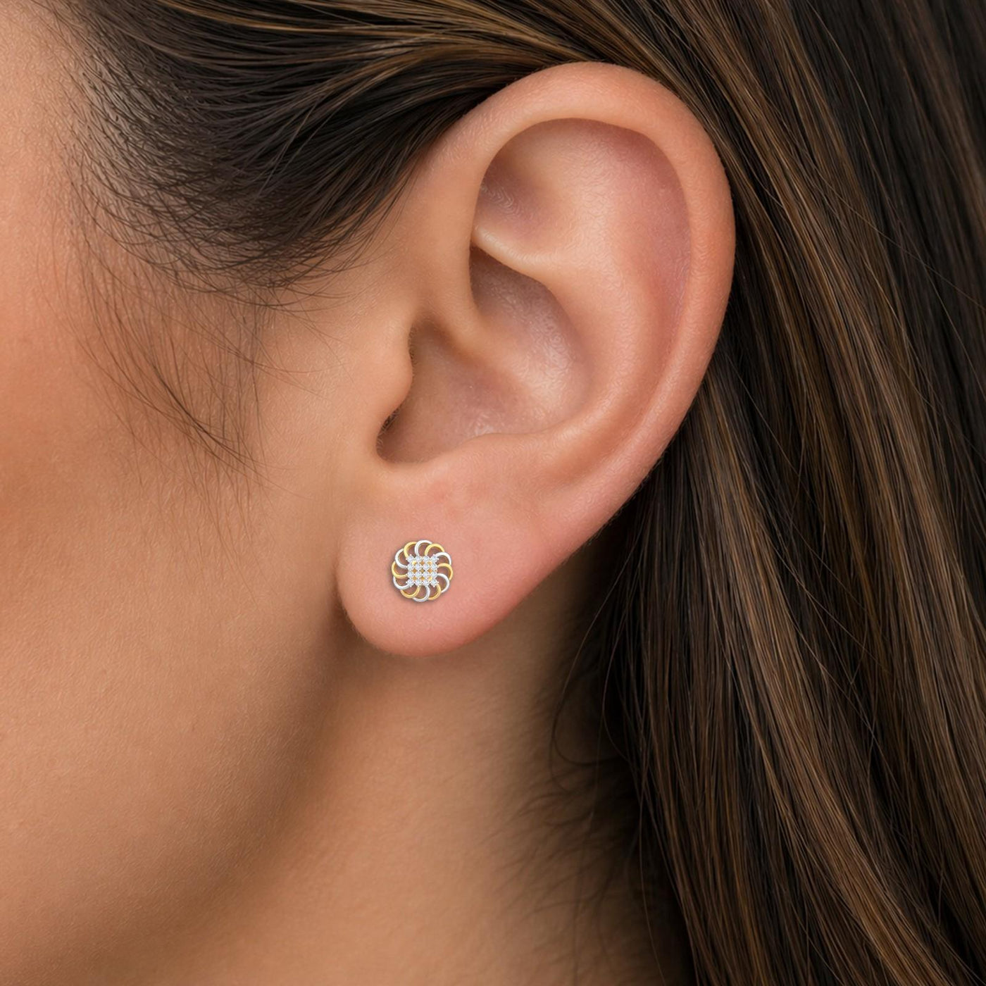 Close-up shot of a gold and diamond floral stud earrings.