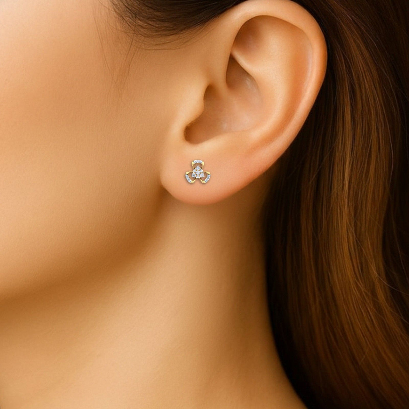 Close-up shot gold and diamond stud earrings with floral-design.