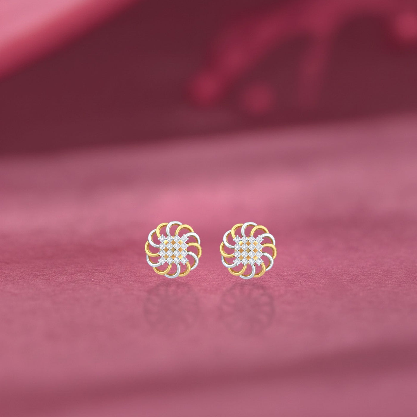 Gold and diamond floral stud earrings on a pink background