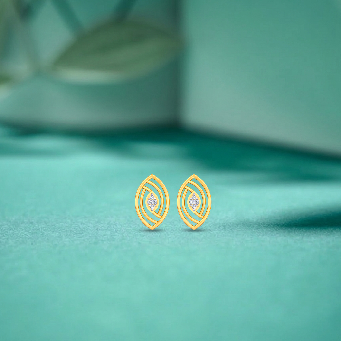 Gold and diamond stud earrings on a fabric background