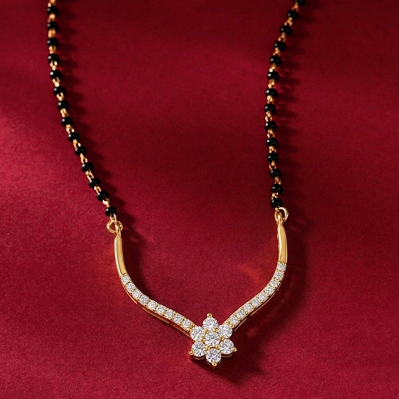 Yellow gold & diamond floral mangalsutra on red background