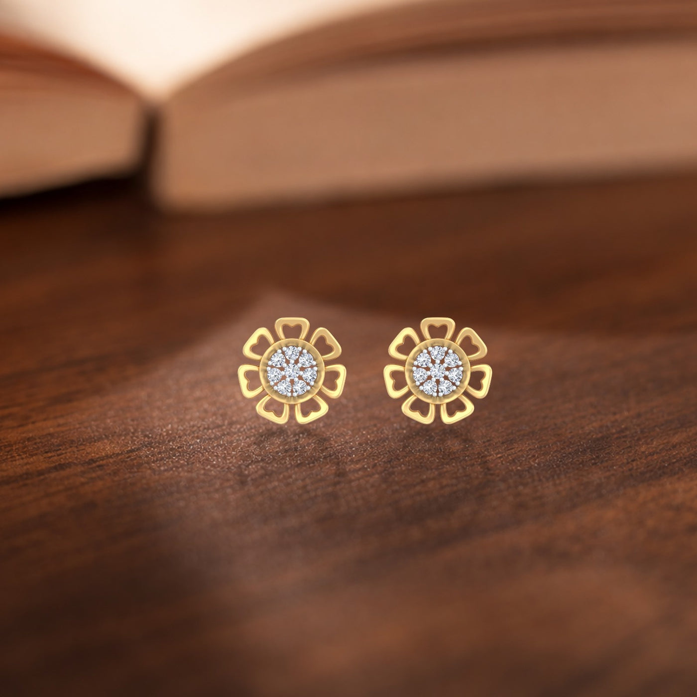 Gold and diamond stud earring with floral-design on a wooden surface.