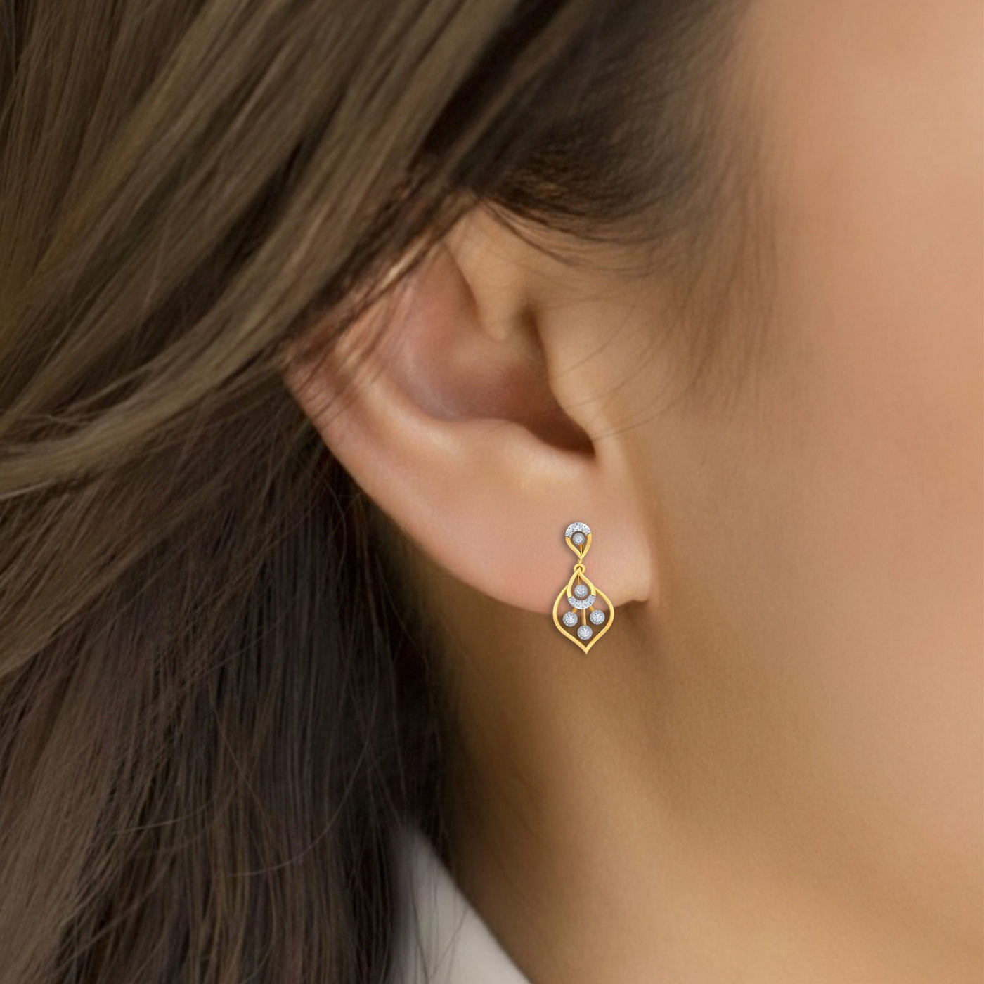 Close-up shot gold and diamond drop earring.