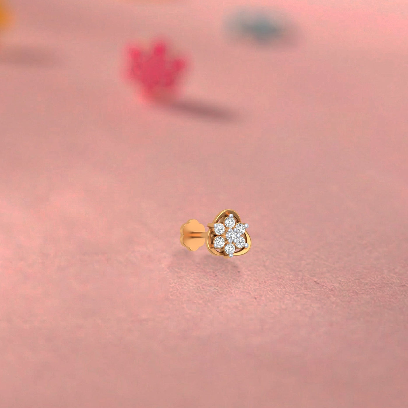 Yellow Gold and diamond stud nose pin heart-shaped earring on a pink background