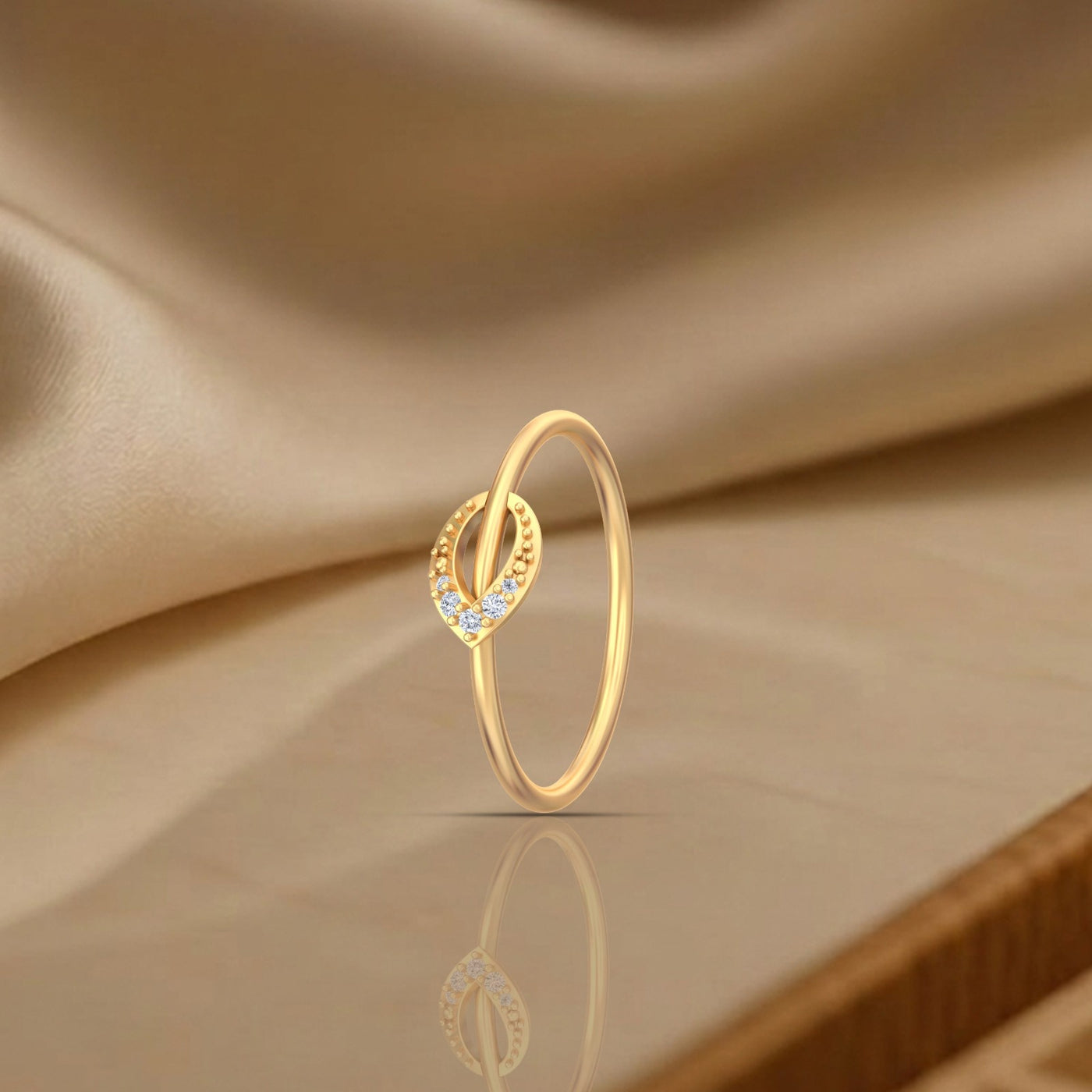 Gold ring with small diamonds on a beige fabric background
