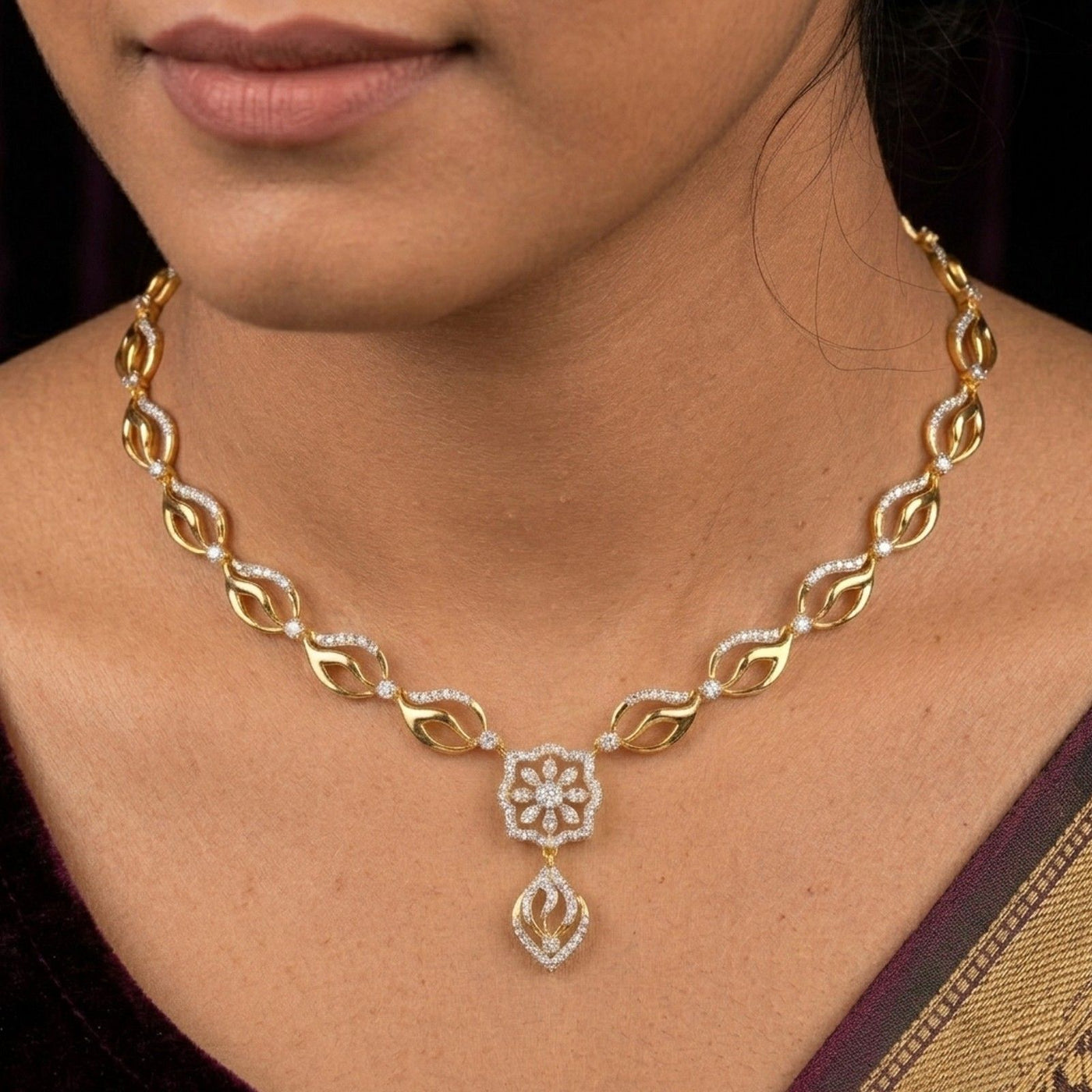 Gold necklace with floral pendant worn by a person