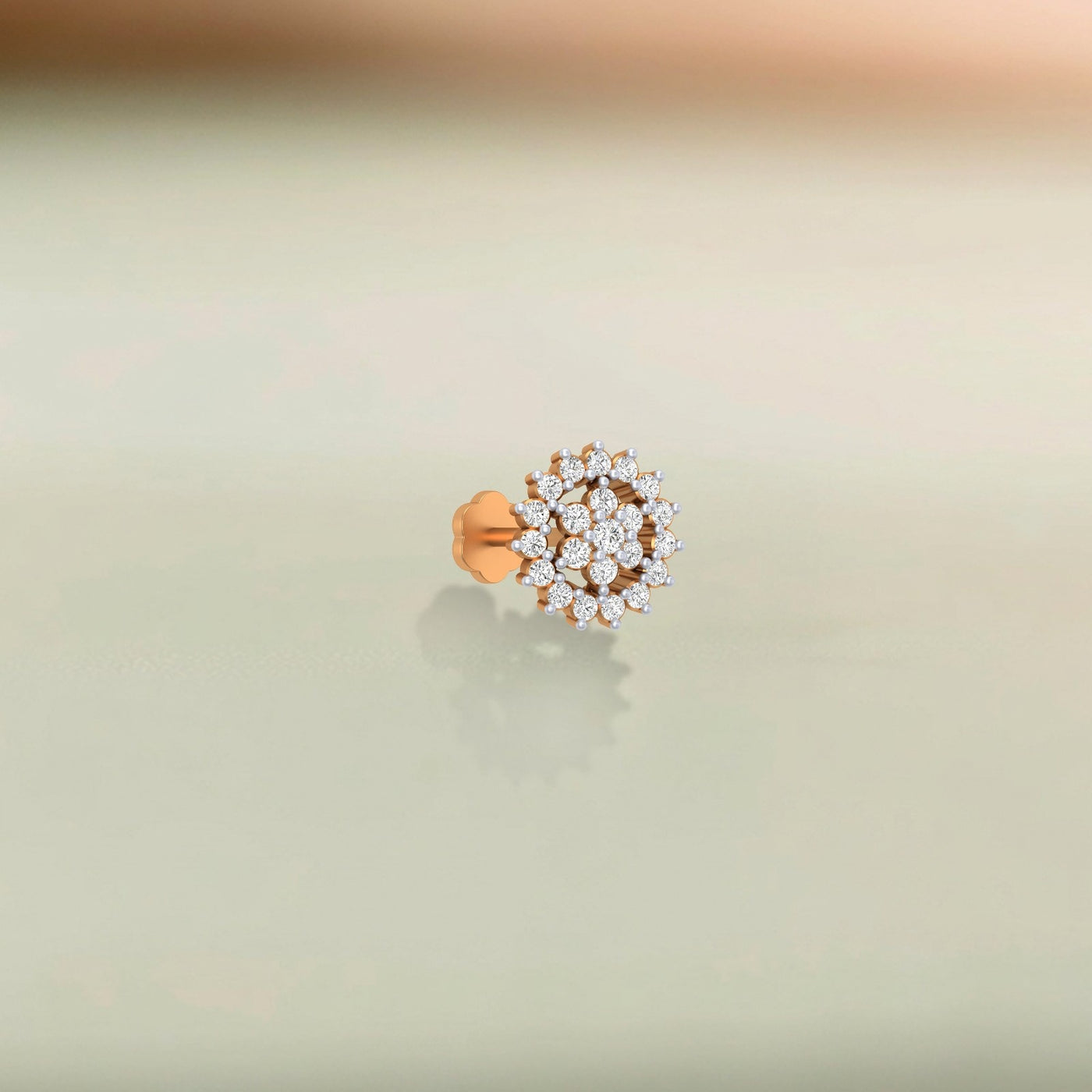 yellow gold and diamond stud nose pin with clear gemstones on a beige background