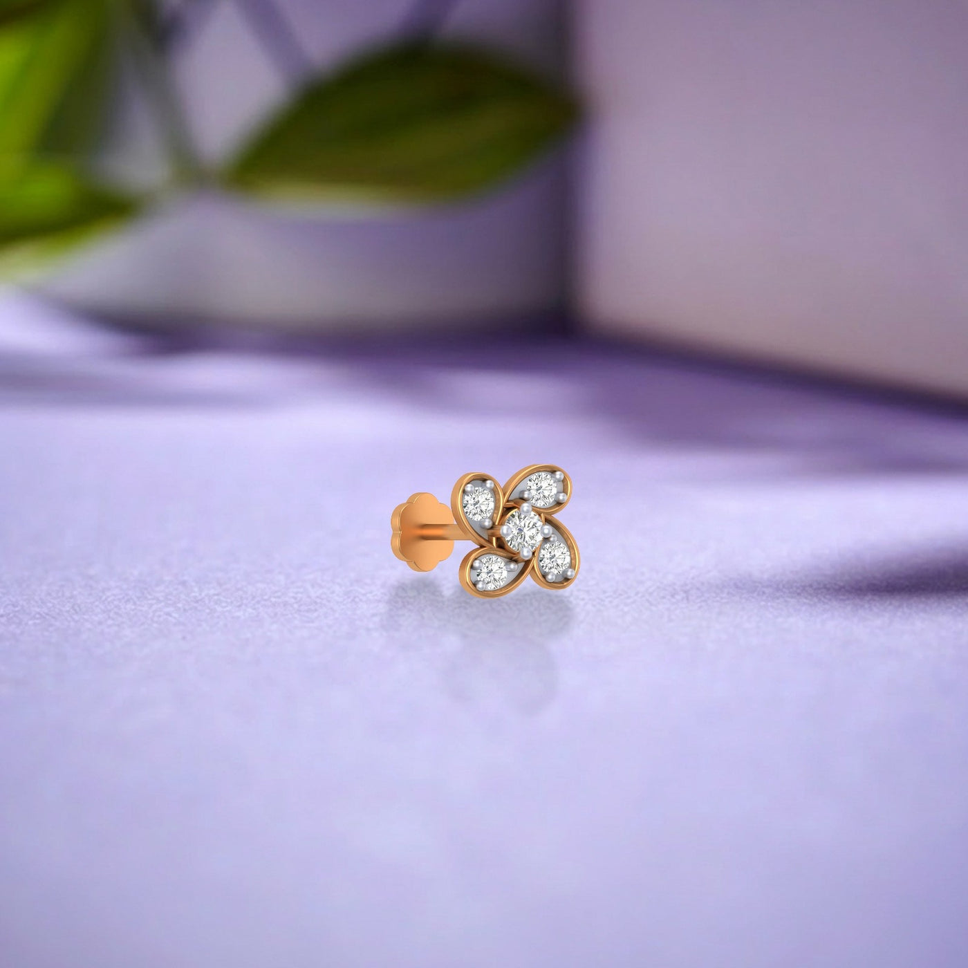 yellow gold and diamond stud with diamonds on a light purple fabric background