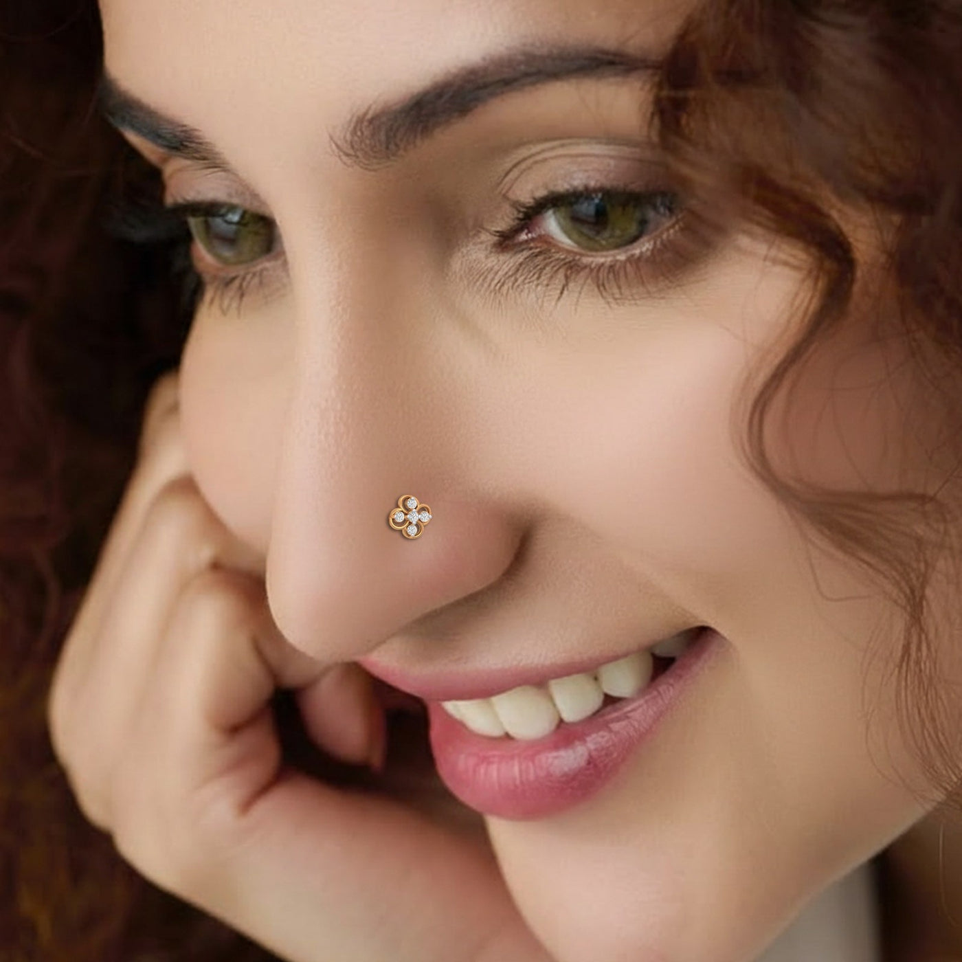 Close-up of a woman with a nose pin, smiling.