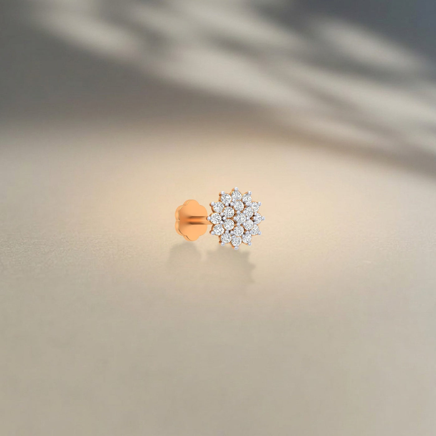 yellow gold and diamond stud nose pin with diamond cluster on a neutral background