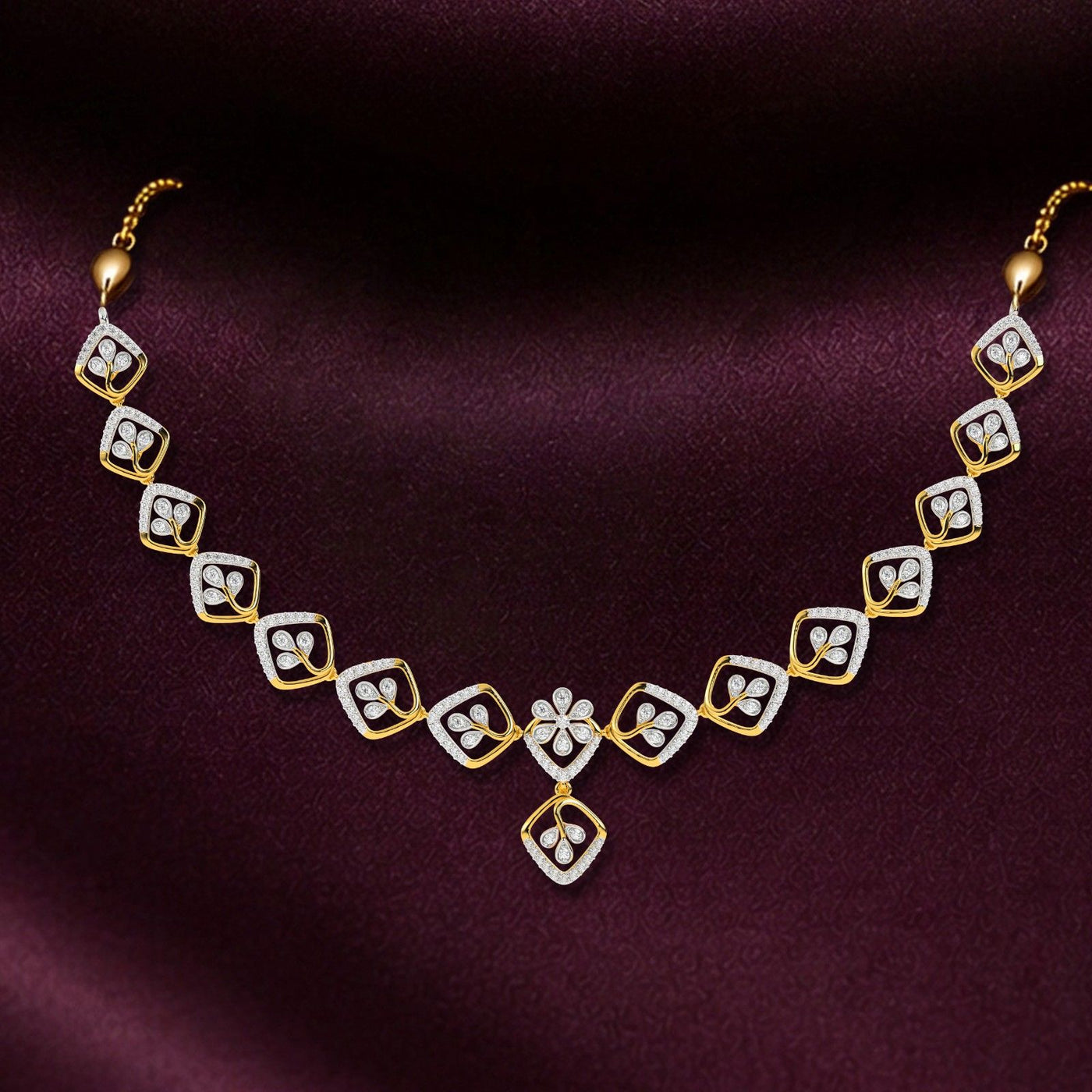 Gold and diamond necklace on a dark purple background.