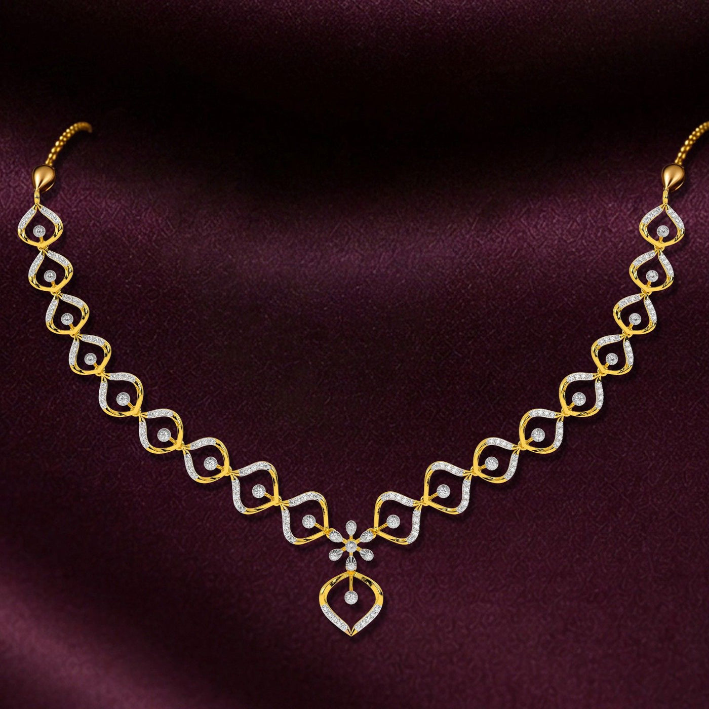 A gold and diamond necklace, displayed on a dark purple satin fabric background.