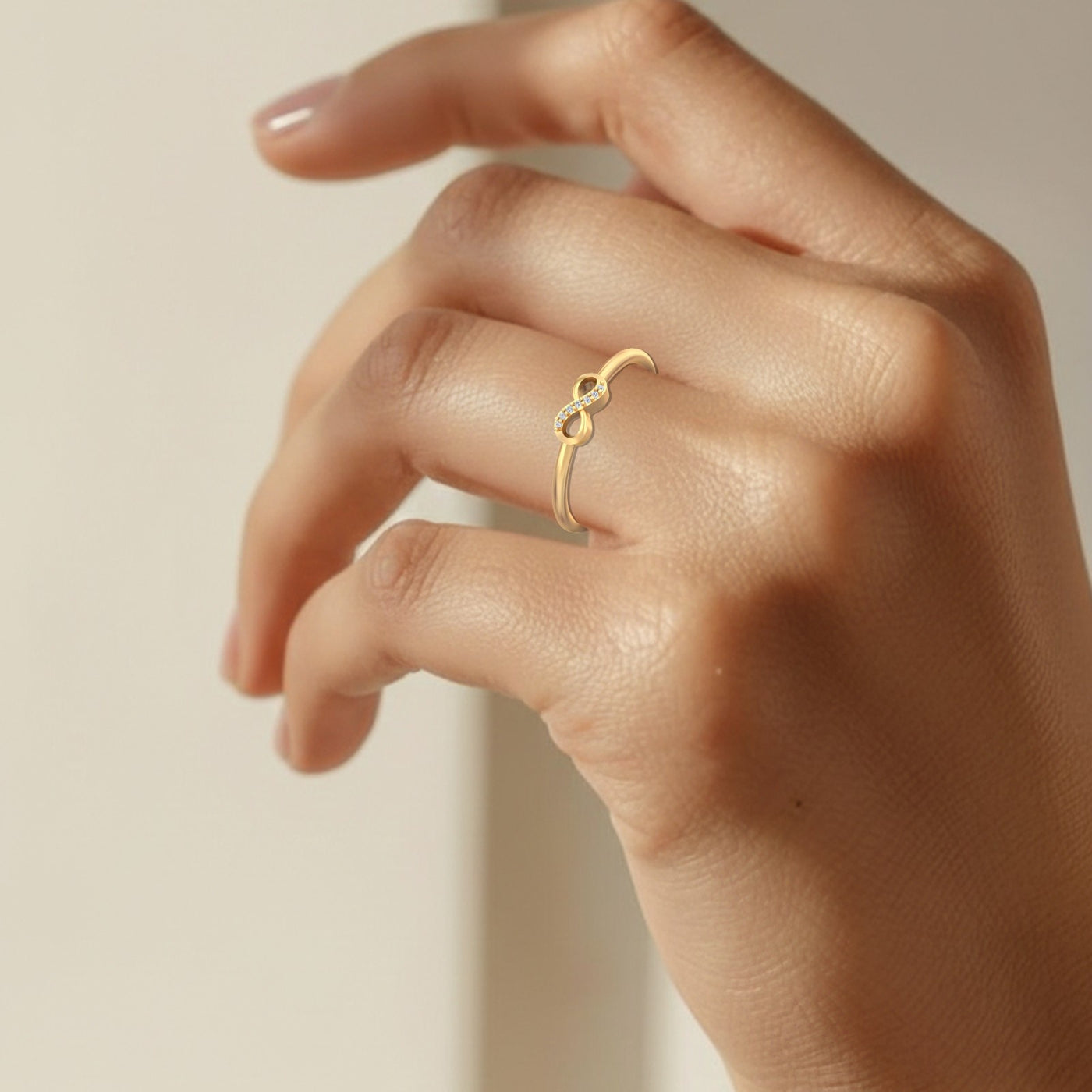 Gold ring on a person's finger against a neutral background
