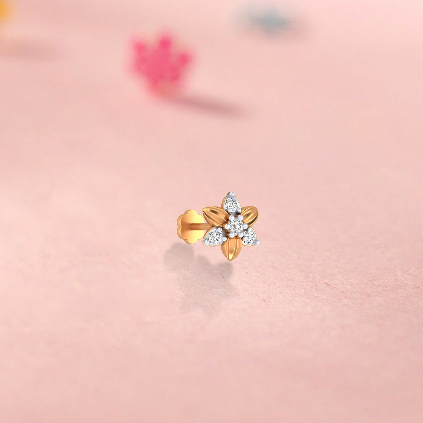 Yellow Gold and diamond stud nose pin on a pink background
