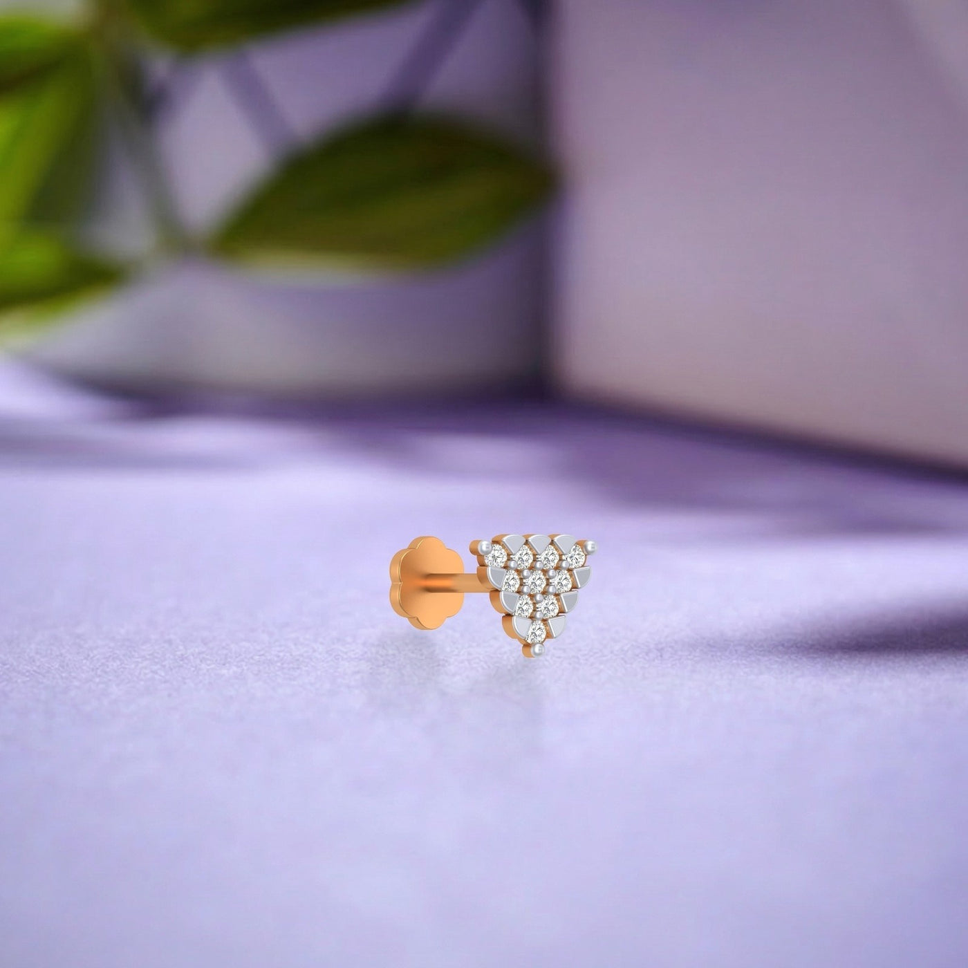 yellow gold and diamond stud nose pin with decorative design on a white surface
