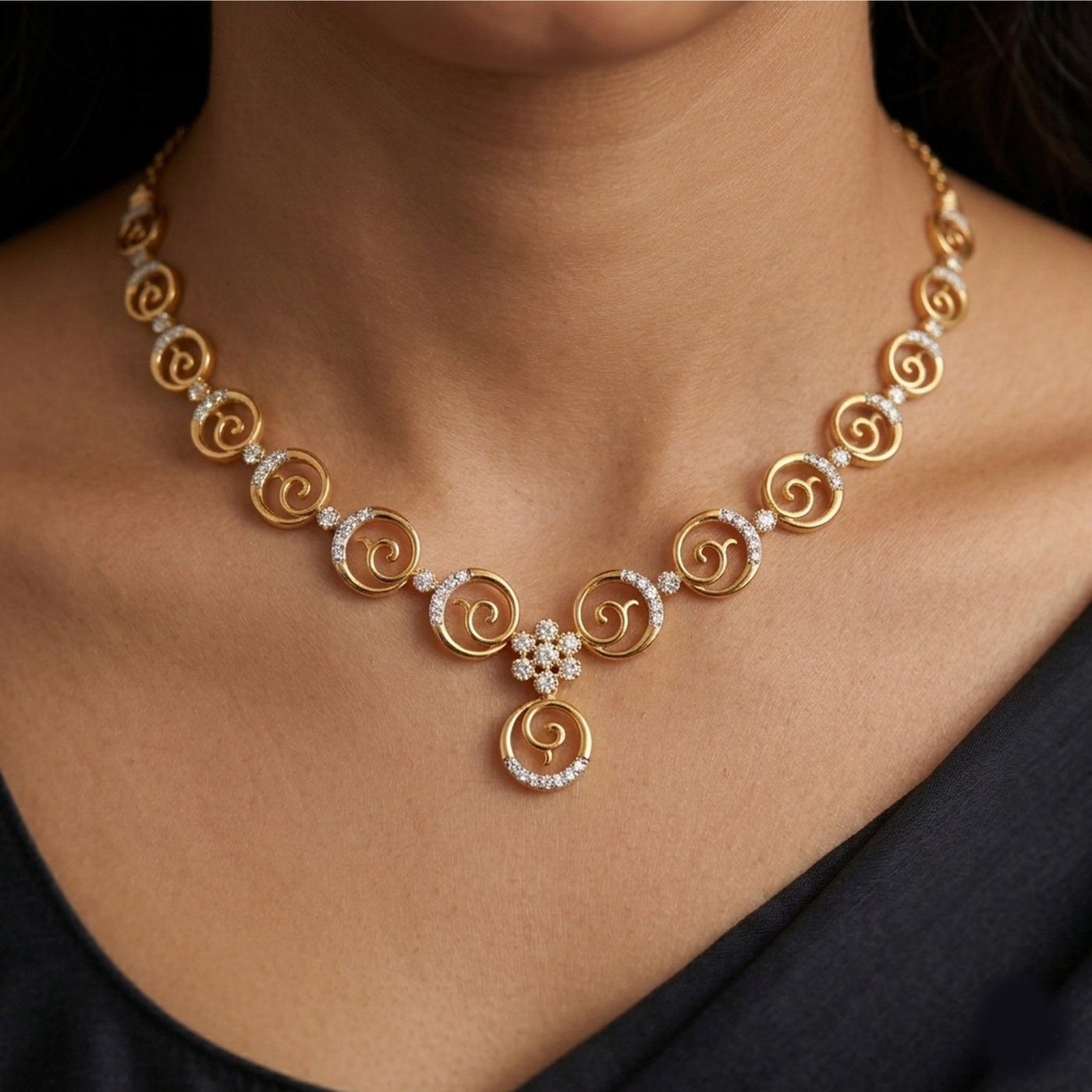 Gold necklace with circular design and pearl accents worn by a person.