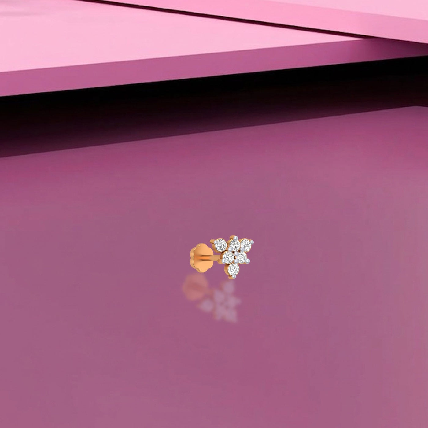 Yellow Gold and diamond stud nose pin on a pink background