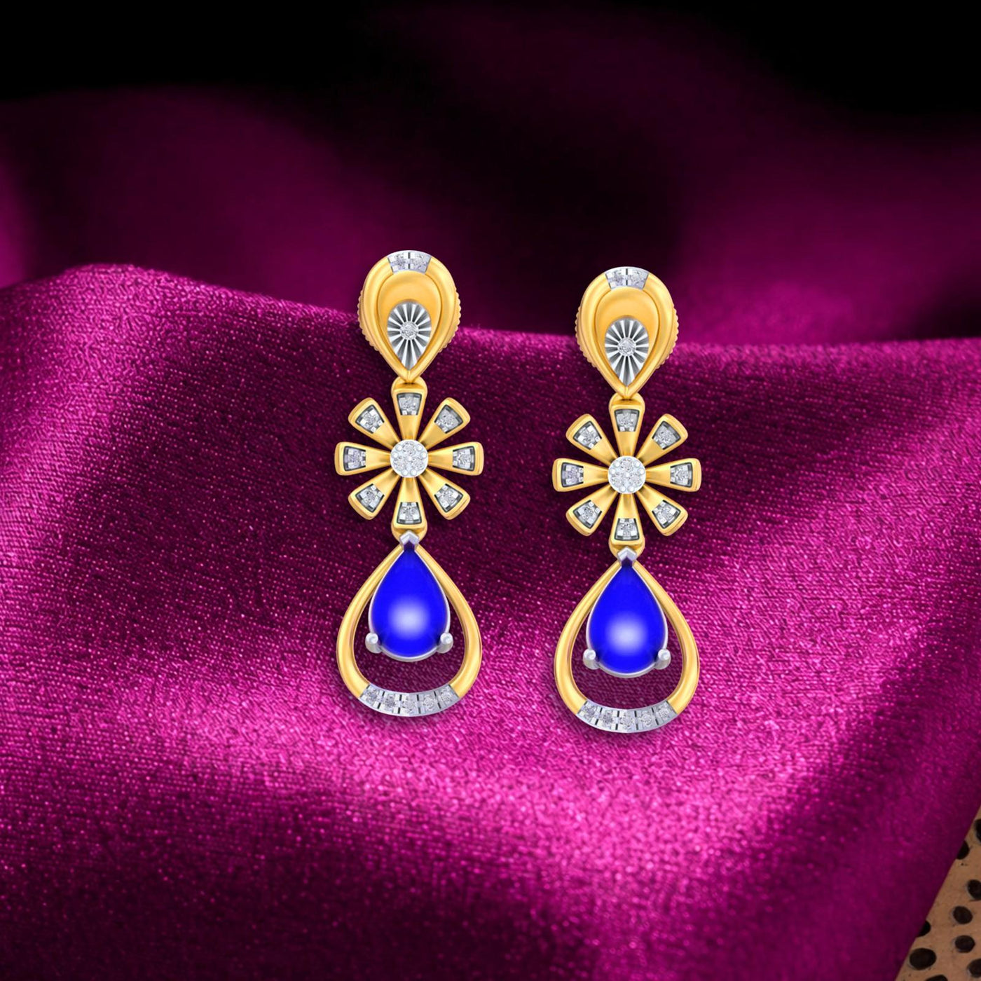 Gold and diamond drop earring with gemstone on a magenta fabric background.