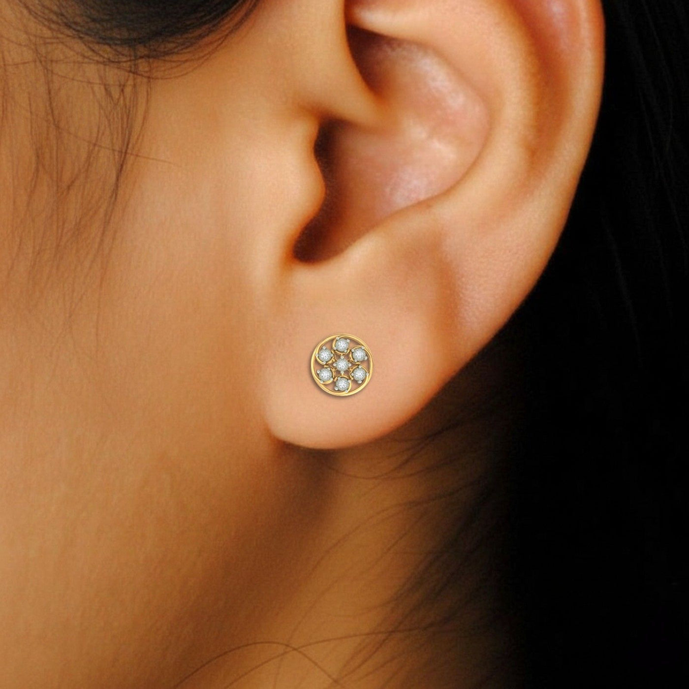 Close-up shot of a gold and diamond stud earring with round-shaped.
