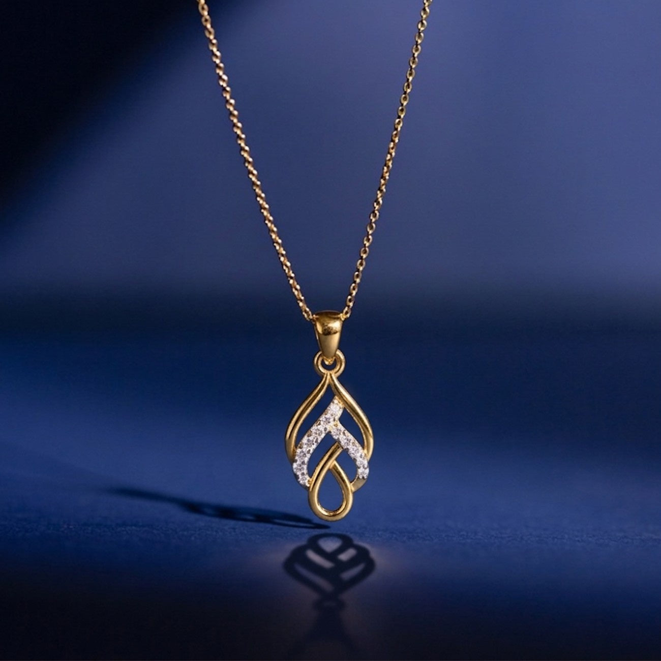 Gold necklace with a teardrop-shaped pendant on a blue background